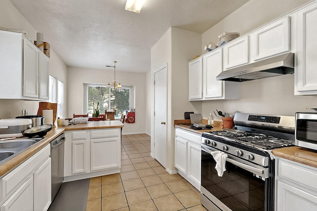 2512 Sarita Ave NW, Albuquerque, NM 87104 - kitchen with stainless steel appliances, under cabinet range hood, light tile patterned floors, white cabinets, and a textured ceiling