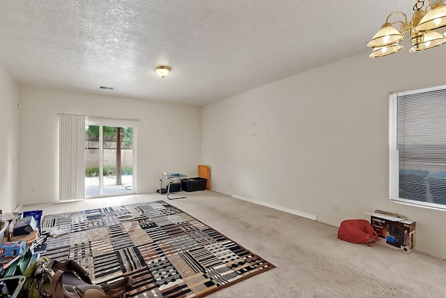 2512 Sarita Ave NW, Albuquerque, NM 87104 - unfurnished bedroom with access to outside, a chandelier, carpet floors, and a textured ceiling