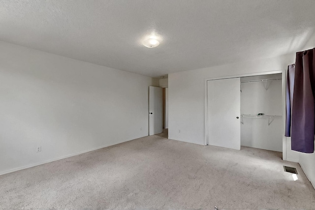 2512 Sarita Ave NW, Albuquerque, NM 87104 - unfurnished bedroom featuring carpet, a closet, a textured ceiling, and baseboards