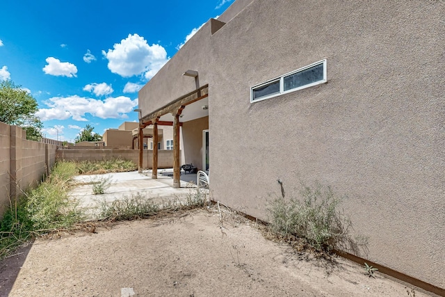 2512 Sarita Ave NW, Albuquerque, NM 87104 - view of side of property with a patio area, stucco siding, and a fenced backyard