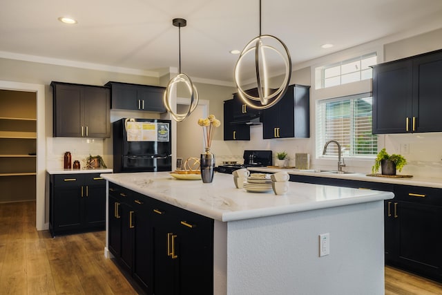 1899 Vargas Rd SE, Rio Rancho, NM 87124 - kitchen with black appliances, a center island, a sink, tasteful backsplash, and pendant lighting