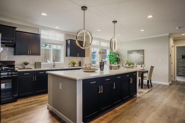1899 Vargas Rd SE, Rio Rancho, NM 87124 - kitchen with gas stove, a sink, light countertops, a center island, and under cabinet range hood