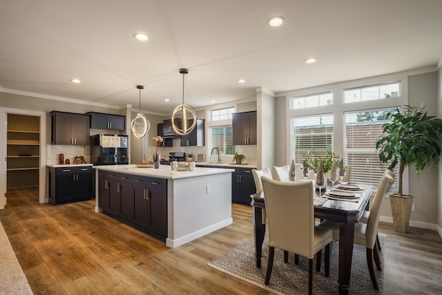 1899 Vargas Rd SE, Rio Rancho, NM 87124 - kitchen with recessed lighting, light countertops, backsplash, crown molding, and wood finished floors