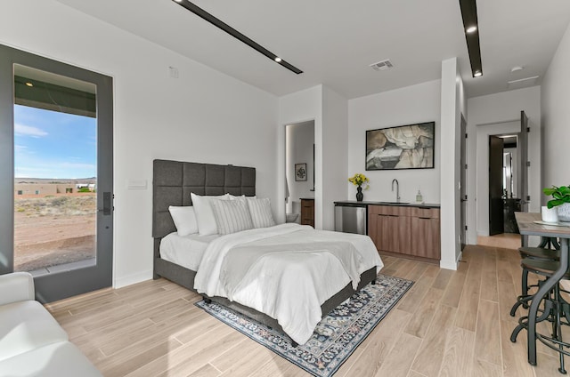 6511 Vista Del Prado, Albuquerque, NM 87120 - bedroom featuring light wood-style flooring, access to outside, bar with sink, and fridge