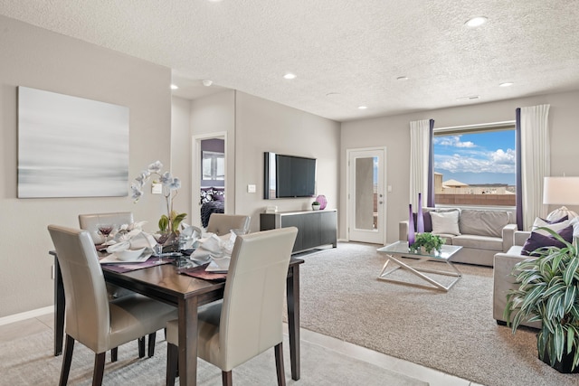 dining room featuring light colored carpet, recessed lighting, a textured ceiling, and baseboards