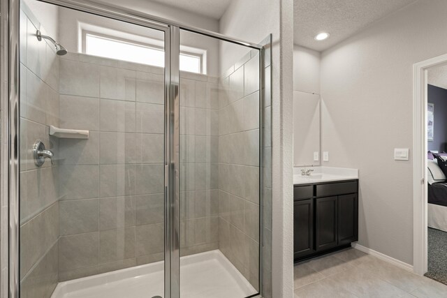 full bath with ensuite bath, a shower stall, and a textured ceiling
