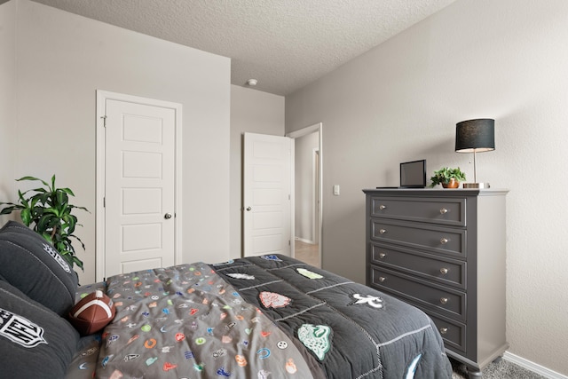 bedroom featuring a textured ceiling, baseboards, and carpet flooring