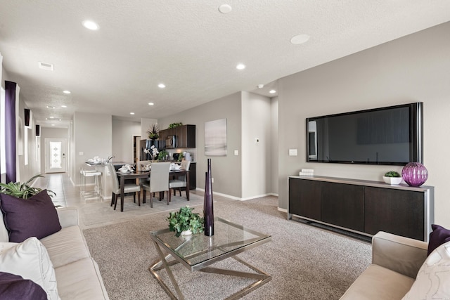 living room featuring recessed lighting, baseboards, and light colored carpet