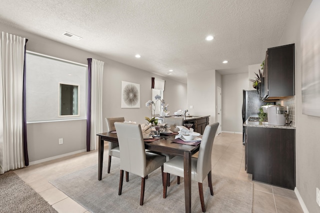 dining room featuring light tile patterned flooring, a textured ceiling, recessed lighting, and baseboards