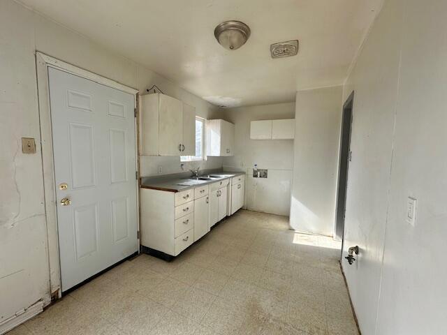 1205 Del Norte Blvd, Grants, NM 87020 - kitchen with light floors, white cabinets, and a sink