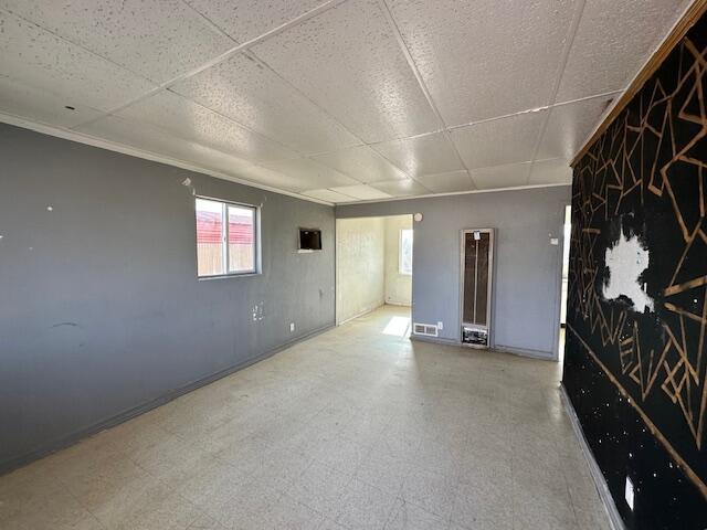1205 Del Norte Blvd, Grants, NM 87020 - empty room with tile patterned floors, a heating unit, baseboards, and a drop ceiling