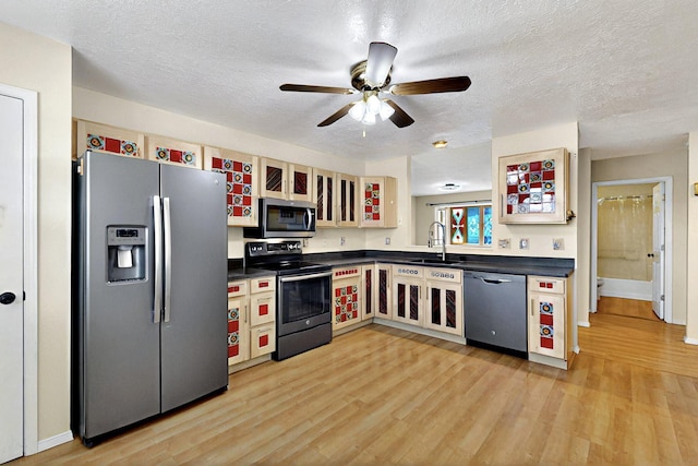 5721 Miller Rd NE, Rio Rancho, NM 87144 - kitchen featuring stainless steel appliances, dark countertops, a sink, light wood finished floors, and ceiling fan
