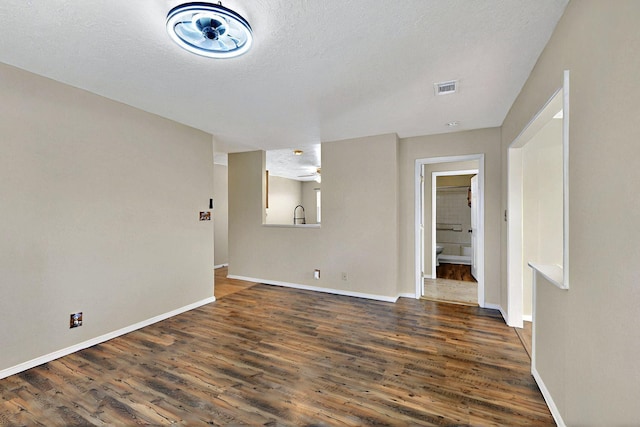 5721 Miller Rd NE, Rio Rancho, NM 87144 - unfurnished room with dark wood-style flooring, baseboards, and a textured ceiling