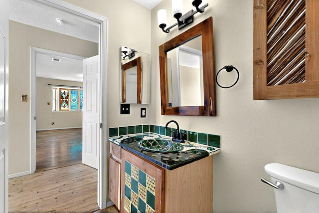 5721 Miller Rd NE, Rio Rancho, NM 87144 - bathroom featuring wood finished floors, toilet, vanity, and baseboards