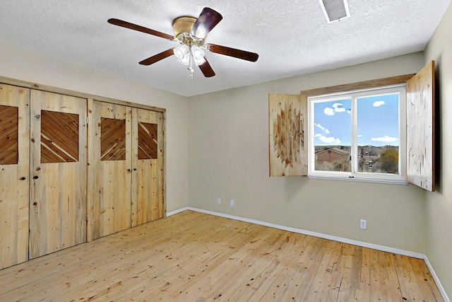 5721 Miller Rd NE, Rio Rancho, NM 87144 - unfurnished bedroom with baseboards, wood-type flooring, a textured ceiling, and a ceiling fan