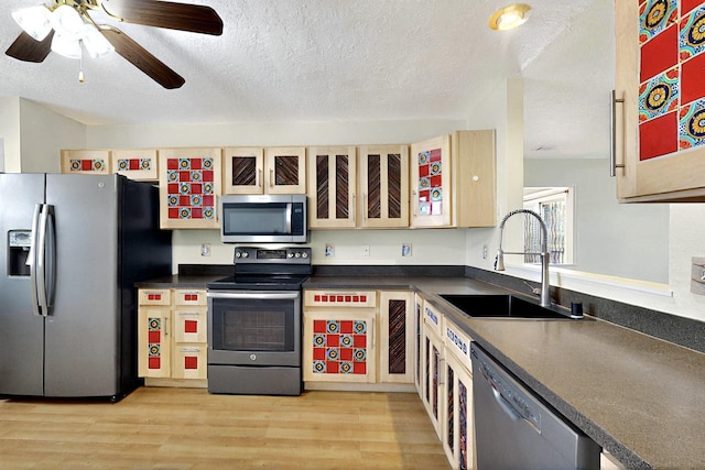 5721 Miller Rd NE, Rio Rancho, NM 87144 - kitchen with appliances with stainless steel finishes, a sink, dark countertops, light wood-style flooring, and a textured ceiling
