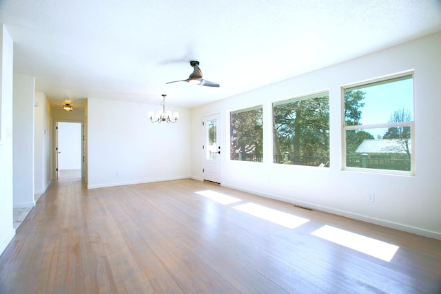 445 Rim Rd, Los Alamos, NM 87544 - empty room with a chandelier, wood finished floors, baseboards, and a ceiling fan