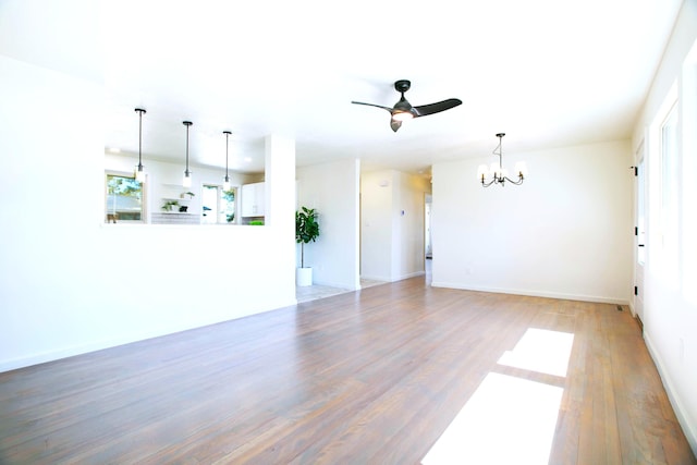 445 Rim Rd, Los Alamos, NM 87544 - unfurnished living room with a chandelier, ceiling fan, light wood finished floors, and baseboards