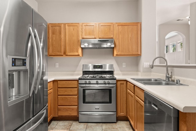 5236 Na Pali St NE, Albuquerque, NM 87111 - kitchen with stainless steel appliances, under cabinet range hood, a sink, light countertops, and arched walkways