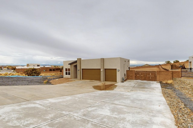 3406 Falkirk Rd NE, Rio Rancho, NM 87144 - view of property exterior with concrete driveway, a garage, stucco siding, and fence