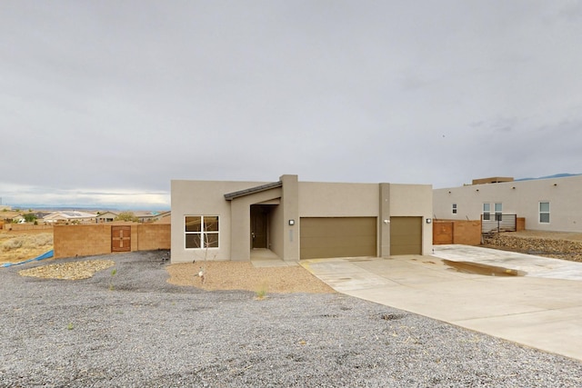 3406 Falkirk Rd NE, Rio Rancho, NM 87144 - view of front of home featuring an attached garage, driveway, stucco siding, and fence
