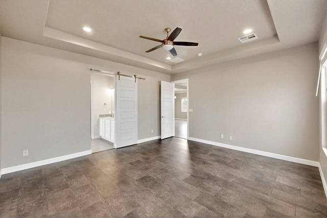3406 Falkirk Rd NE, Rio Rancho, NM 87144 - unfurnished bedroom with a raised ceiling, a barn door, baseboards, recessed lighting, and ensuite bath