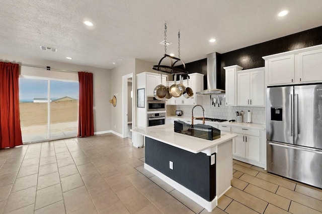 3406 Falkirk Rd NE, Rio Rancho, NM 87144 - kitchen featuring stainless steel fridge, wall chimney exhaust hood, backsplash, light countertops, and recessed lighting