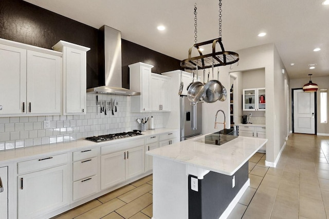 3406 Falkirk Rd NE, Rio Rancho, NM 87144 - kitchen with wall chimney range hood, stainless steel appliances, decorative backsplash, white cabinets, and recessed lighting