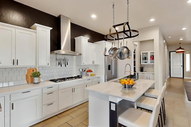 3406 Falkirk Rd NE, Rio Rancho, NM 87144 - kitchen featuring appliances with stainless steel finishes, wall chimney exhaust hood, a sink, light tile patterned floors, and recessed lighting