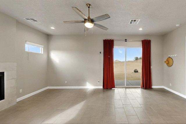 3406 Falkirk Rd NE, Rio Rancho, NM 87144 - spare room featuring a ceiling fan, baseboards, a fireplace, recessed lighting, and a textured ceiling