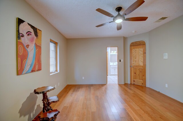 4700 Quaker Heights Pl NW, Albuquerque, NM 87120 - spare room with light wood-type flooring, ceiling fan, arched walkways, and a textured ceiling