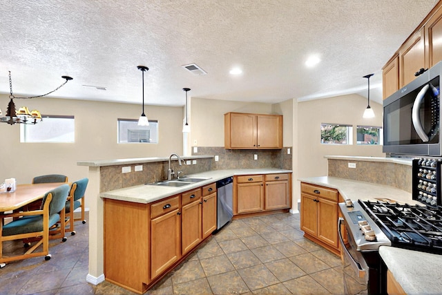 10912 Saltillo St NW, Albuquerque, NM 87114 - kitchen featuring stainless steel appliances, a sink, tasteful backsplash, a peninsula, and a textured ceiling