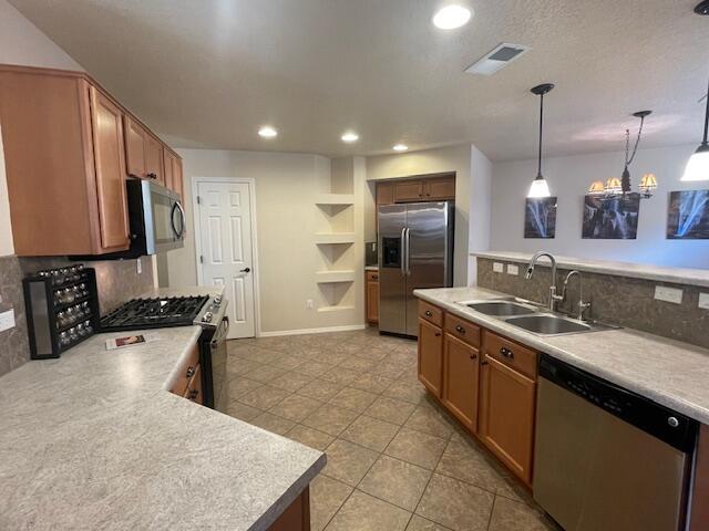 10912 Saltillo St NW, Albuquerque, NM 87114 - kitchen featuring stainless steel appliances, a sink, tasteful backsplash, light tile patterned floors, and recessed lighting