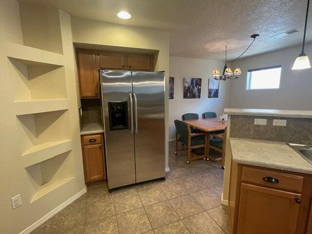 10912 Saltillo St NW, Albuquerque, NM 87114 - kitchen featuring stainless steel refrigerator with ice dispenser, open shelves, brown cabinets, a chandelier, and decorative light fixtures