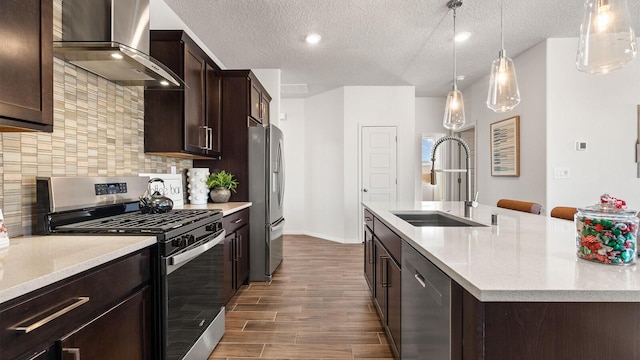 4114 Silver Springs Rd NE, Rio Rancho, NM 87144 - kitchen featuring appliances with stainless steel finishes, wall chimney range hood, a sink, dark wood finished floors, and dark brown cabinetry