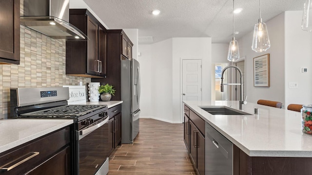 4114 Silver Springs Rd NE, Rio Rancho, NM 87144 - kitchen featuring appliances with stainless steel finishes, wall chimney exhaust hood, a sink, dark wood-style flooring, and a kitchen island with sink