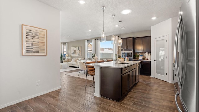 4114 Silver Springs Rd NE, Rio Rancho, NM 87144 - kitchen featuring freestanding refrigerator, a sink, dark brown cabinets, light countertops, and dark wood-style flooring
