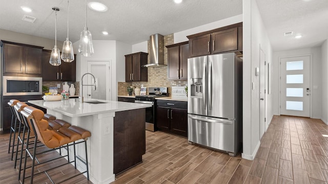4114 Silver Springs Rd NE, Rio Rancho, NM 87144 - kitchen featuring appliances with stainless steel finishes, wall chimney exhaust hood, a sink, wood finished floors, and decorative backsplash