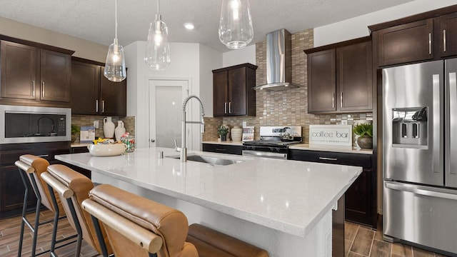 4114 Silver Springs Rd NE, Rio Rancho, NM 87144 - kitchen featuring stainless steel appliances, wall chimney exhaust hood, a sink, a textured ceiling, and dark brown cabinets