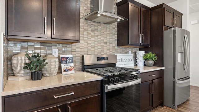 4114 Silver Springs Rd NE, Rio Rancho, NM 87144 - kitchen with appliances with stainless steel finishes, wall chimney range hood, dark brown cabinetry, light wood-type flooring, and tasteful backsplash