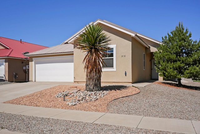 ranch-style house featuring stucco siding, driveway, an attached garage, and metal roof