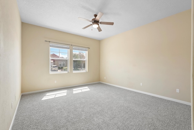 spare room with ceiling fan, carpet, baseboards, and a textured ceiling