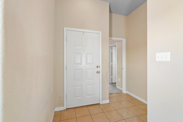 entryway with light tile patterned flooring and baseboards