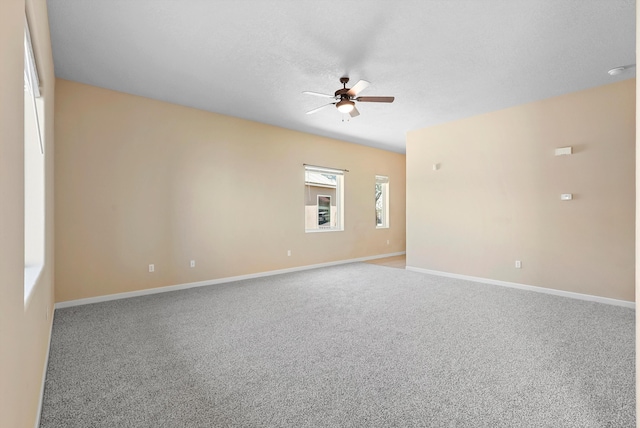 empty room featuring a ceiling fan, carpet, and baseboards