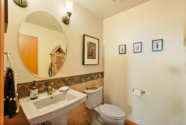 6119 La Paz Rd NE, Rio Rancho, NM 87144 - half bath with a sink, toilet, a textured ceiling, and tile walls