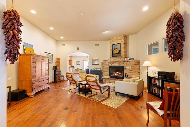 6119 La Paz Rd NE, Rio Rancho, NM 87144 - living area featuring arched walkways, a stone fireplace, light wood-type flooring, and recessed lighting