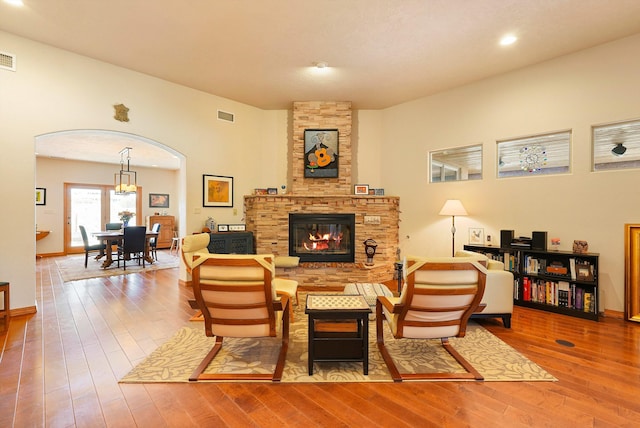 6119 La Paz Rd NE, Rio Rancho, NM 87144 - living room with arched walkways, wood finished floors, a fireplace, and baseboards