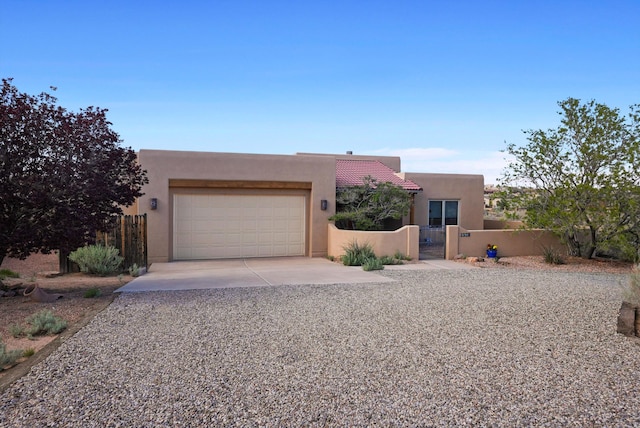 6119 La Paz Rd NE, Rio Rancho, NM 87144 - pueblo revival-style home with concrete driveway, a garage, stucco siding, and a tiled roof