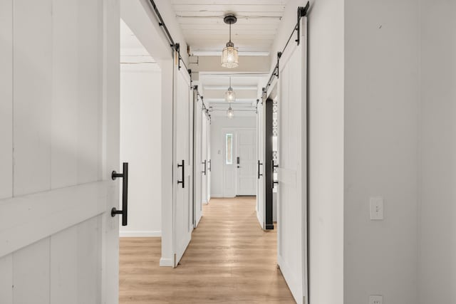 384 Chaparral Ln, Corrales, NM 87048 - hallway featuring a barn door, light wood-style flooring, and baseboards