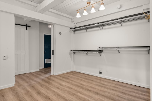 384 Chaparral Ln, Corrales, NM 87048 - spacious closet featuring a barn door, light wood-type flooring, and beam ceiling